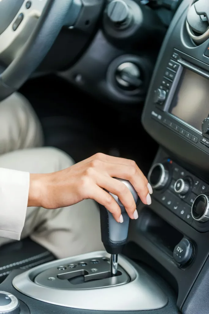 Hand on an automatic transmission shifter in a vehicle interior — drivetrain services at Rite-Price Auto Service Centre in Calgary, AB
