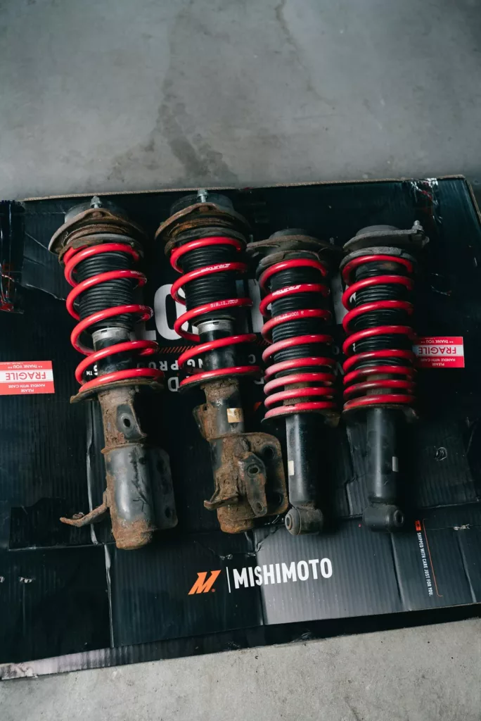 Set of four coilover struts with red coil springs ready for installation — shocks and struts replacement at Rite-Price Auto Service Centre in Calgary, AB