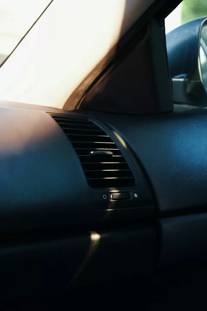 Close-up of a car dashboard air vent in warm afternoon light — heater and defrost service at Rite-Price Auto Service Centre in Calgary, AB