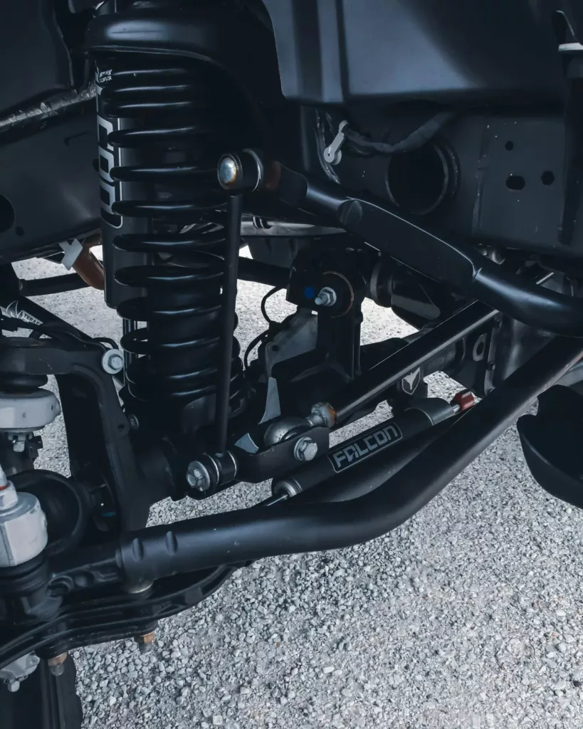 Underbody view of a coil-spring suspension and control arm — steering and suspension repair at Rite-Price Auto Service Centre in Calgary, AB